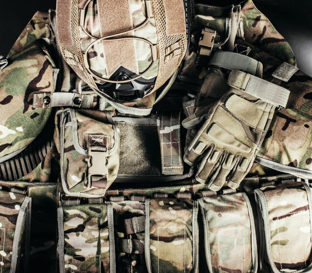 Close-up of tactical military gear with camouflage helmet and gloves showcasing readiness.